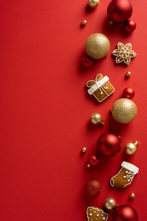 Vertical festive scene with red and gold ornaments, glitter balls, gingerbread cookies, and wrapped gifts, capturing holiday warmth and celebration for Christmas and New Year greetingの写真素材