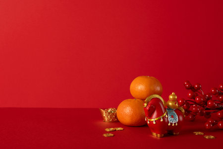 Side view of a red backdrop with oranges, gold accents, and festive decorations for Chinese New Year. Greeting symbols convey wishes for luck, prosperity, and happiness in the new yearの写真素材