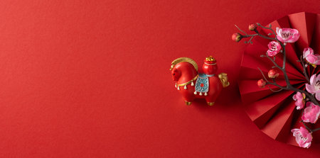 Vibrant banner red backdrop features a decorative lantern horse and pink blossom accents, capturing festive Chinese New Year mood, luck, and traditional celebrationの写真素材