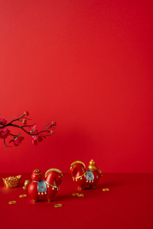 Vivid red scene showcasing Chinese New Year decor with lucky horse figurines, plum blossoms, and gold coins reflecting prosperity and joy in celebration. Side vertical viewの写真素材