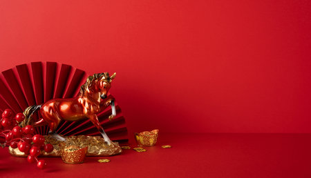 Side view of a festive red scene with a golden horse, coins and a fan symbolizing Chinese New Year luck and prosperityの写真素材