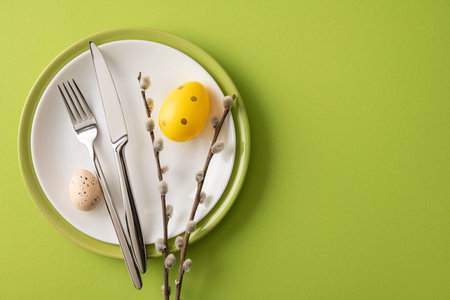 Festive Happy Easter table setting with painted eggs, pussywillow branches and stainless cutlery...