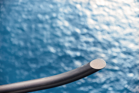 A helicopter skid flying over a body of water on a clear dayの写真素材