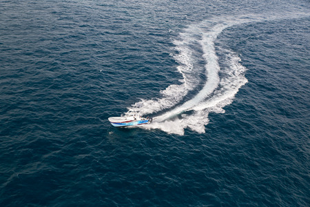Fast motorboat with splash and wake on an oceanの写真素材