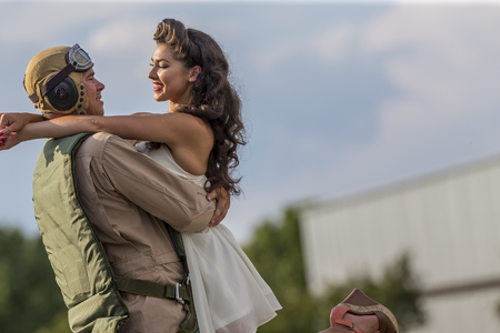 A brunette model in vintage clothing with a pilot and a WW II aircraftの写真素材