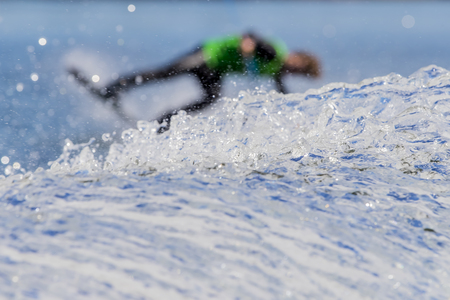 A young athlete wake boards on a body of waterの写真素材