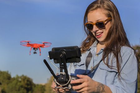 A brunette coed flying a drone in the outdoorsの写真素材