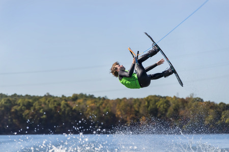 A young athlete wake boards on a body of water