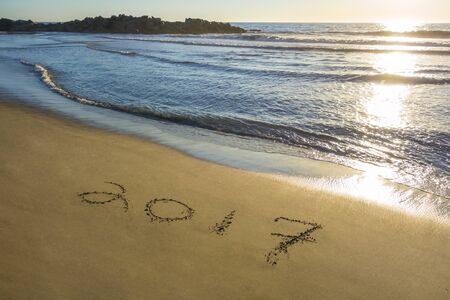 2017 written in the sand with a view of the oceanの写真素材
