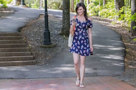 A brunette model enjoying a day on a college campusの写真素材