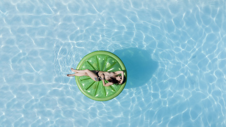 A model poses topless in a swimming pool environment.の写真素材