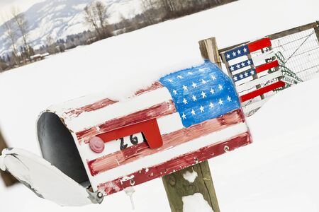 An American Flag mailbox is covered with snow after a winter storm.の写真素材