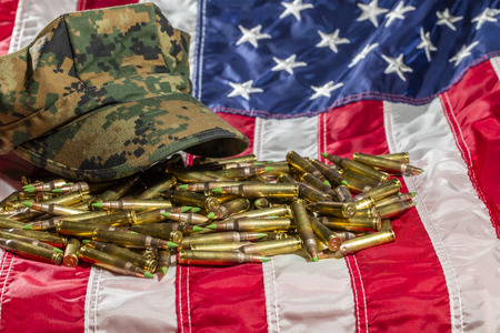 Military cover on an American Flag with rifle ammunition 