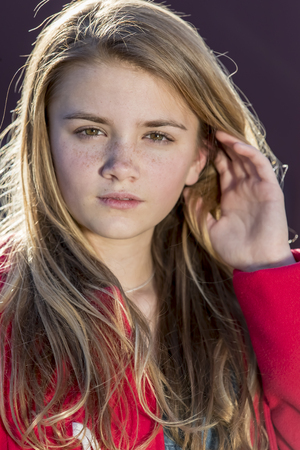 A beautiful young teenage blonde girl enjoying a beautiful day.の写真素材