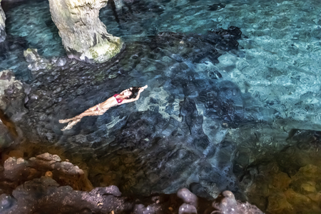 A beautiful hispanic brunette model enjoying a swim in a local cenote near Yucatan, Mexico.