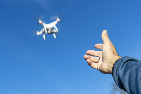 A group of drones fly through the air against a blue sky