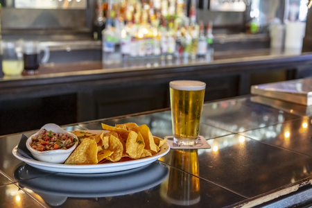 Mexican nacho chips and salsa dip dish on a bar backgroundの写真素材