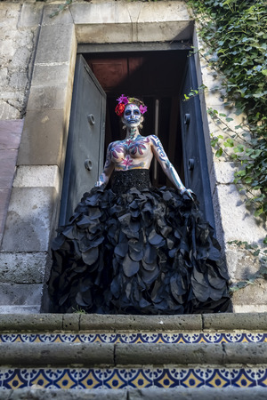 A gorgeous Hispanic Brunette model poses with traditional skull sugar makeup paint for a Mexican festival.の写真素材