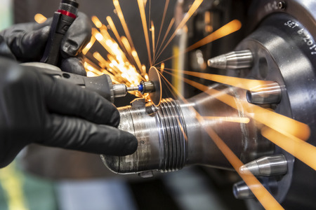 A mechanic grinds down a wheel hub, making sparks from the grinding wheelStreets of Toronto plays...