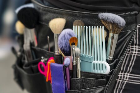 A professional makeup artist applies makeup to a model during a commercial photo shoot