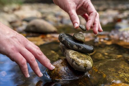Stones arranged in zen towers by the river bed on a summers day