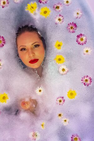 A gorgeous brunette hispanic woman takes a luxurious bath at homeの写真素材