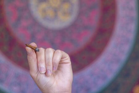 A beautiful brunette model smokes marijuana in the privacy of her own homeの写真素材