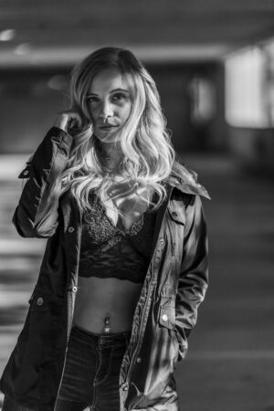 A gorgeous blonde model poses in a parking deck on an autumn dayの写真素材