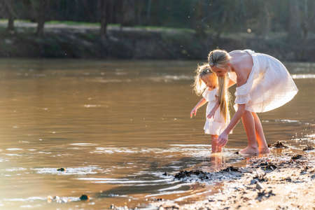 A beautiful young mother and her daughter enjoy the spring weatherの写真素材