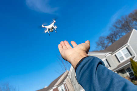 A group of drones fly through the air against a blue sky