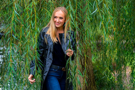 A gorgeous blonde model poses outdoors in her fall clothes
