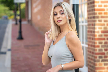 A gorgeous young blonde model poses outdoors while enjoying a summers day