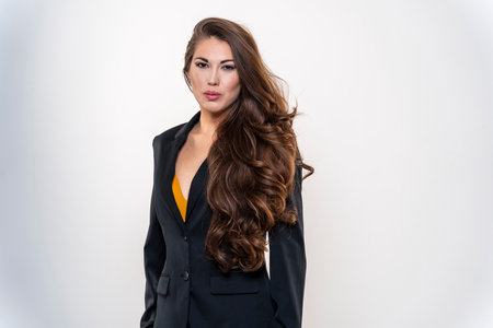 A beautiful mixed race model poses in a business suit in a studio environmentの写真素材