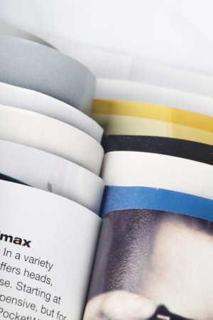 Numerous magazines spread out against a white background in a studio environment
