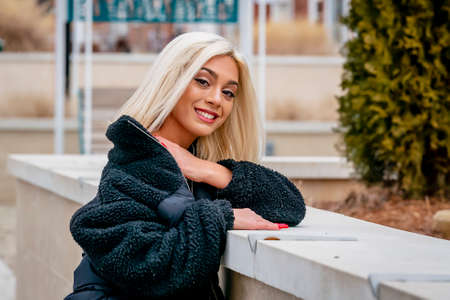 A gorgeous young blonde model poses outdoors while enjoying a winters day