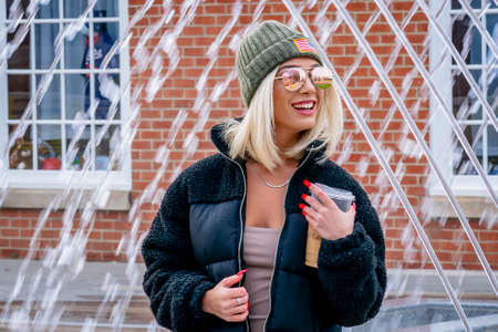 A gorgeous young blonde model poses outdoors while enjoying a winters day in a city environment...