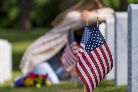 A young bride shows her grief at the burial site of a family member at a military cemetery