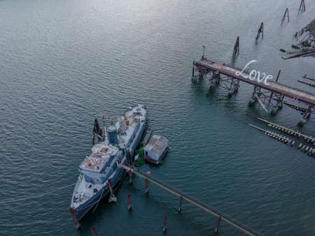 A old abandoned vessel sits on the dock near a riverの写真素材