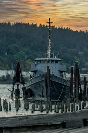 A old abandoned vessel sits on the dock near a riverの写真素材