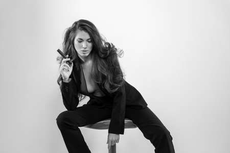 A beautiful mixed race model poses in a business suit in a studio environmentの写真素材