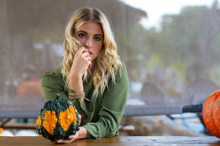 A gorgeous Blonde model poses in a pumpkin field during the halloween holidaysの写真素材