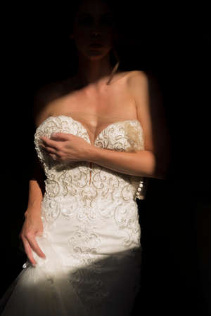 A gorgeous brunette bride poses in her wedding dress before the big dayの写真素材