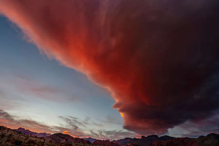 Storm clouds race through the sky in the Arizona desert near a lone highway