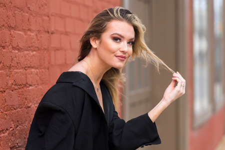 A gorgeous blonde model poses outdoors while enjoying the fall weatherの写真素材
