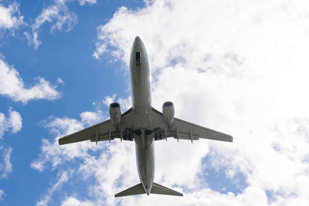 A commercial aircraft landing at an airport against an afternoon sky