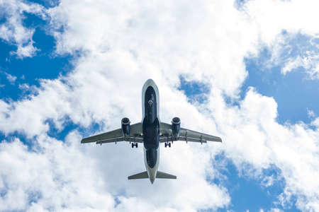 A commercial aircraft landing at an airport against an afternoon sky