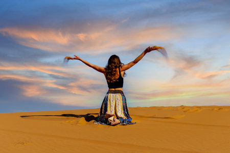 A beautiful model poses against the sand dunes in the great Sahara desert in Moroccoの写真素材