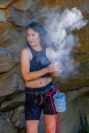 A gorgeous mixed race brunette fitness model climbs rocks in the early afternoon in the Pacific Northwest, U.S.A.の写真素材