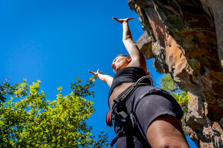A gorgeous mixed race brunette fitness model climbs rocks in the early afternoon in the Pacific...