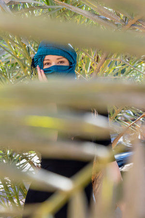A beautiful model wears a hijab in the middle of the Sahara desertの写真素材